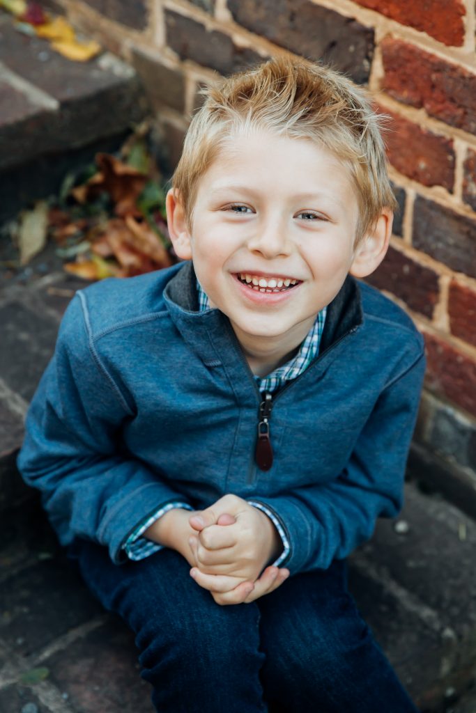 Small boy sitting on brick steps at Aldie Mill in Loudoun County VA