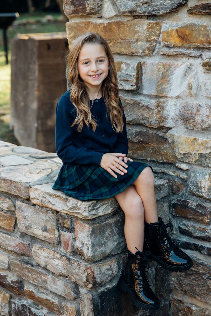 Girl sitting on stone wall posing for portraits