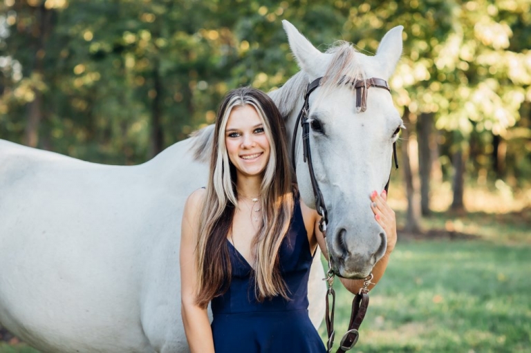 18 year old girl with long blonde hair holding horses head in Haymarket VA Virginia.