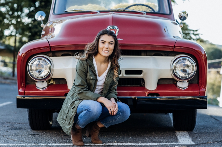 Girl kneeling in front of Vintage Truck by Red Truck Bakery